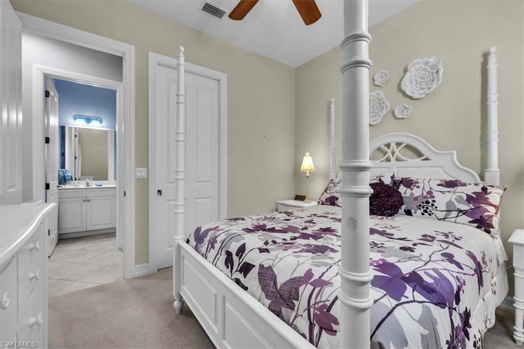 7793 Ashton Road Naples, FL 34113 - Photo 29 of 50 a bedroom with a bed and a chandelier