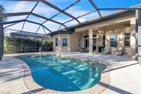 a view of a swimming pool with a yard and sitting area