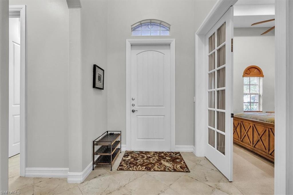 7793 Ashton Road Naples, FL 34113 - Photo 4 of 50 a view of an entryway with wooden floor and cabinet