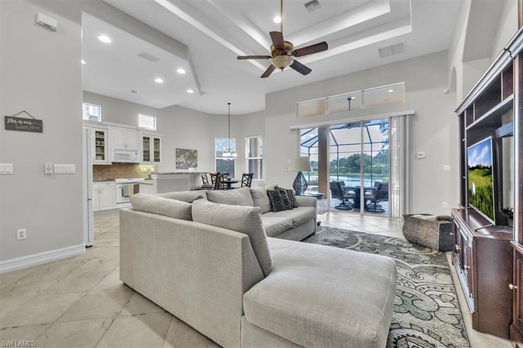 7793 Ashton Road Naples, FL 34113 - Photo 7 of 50 a living room with furniture a flat screen tv and a fireplace