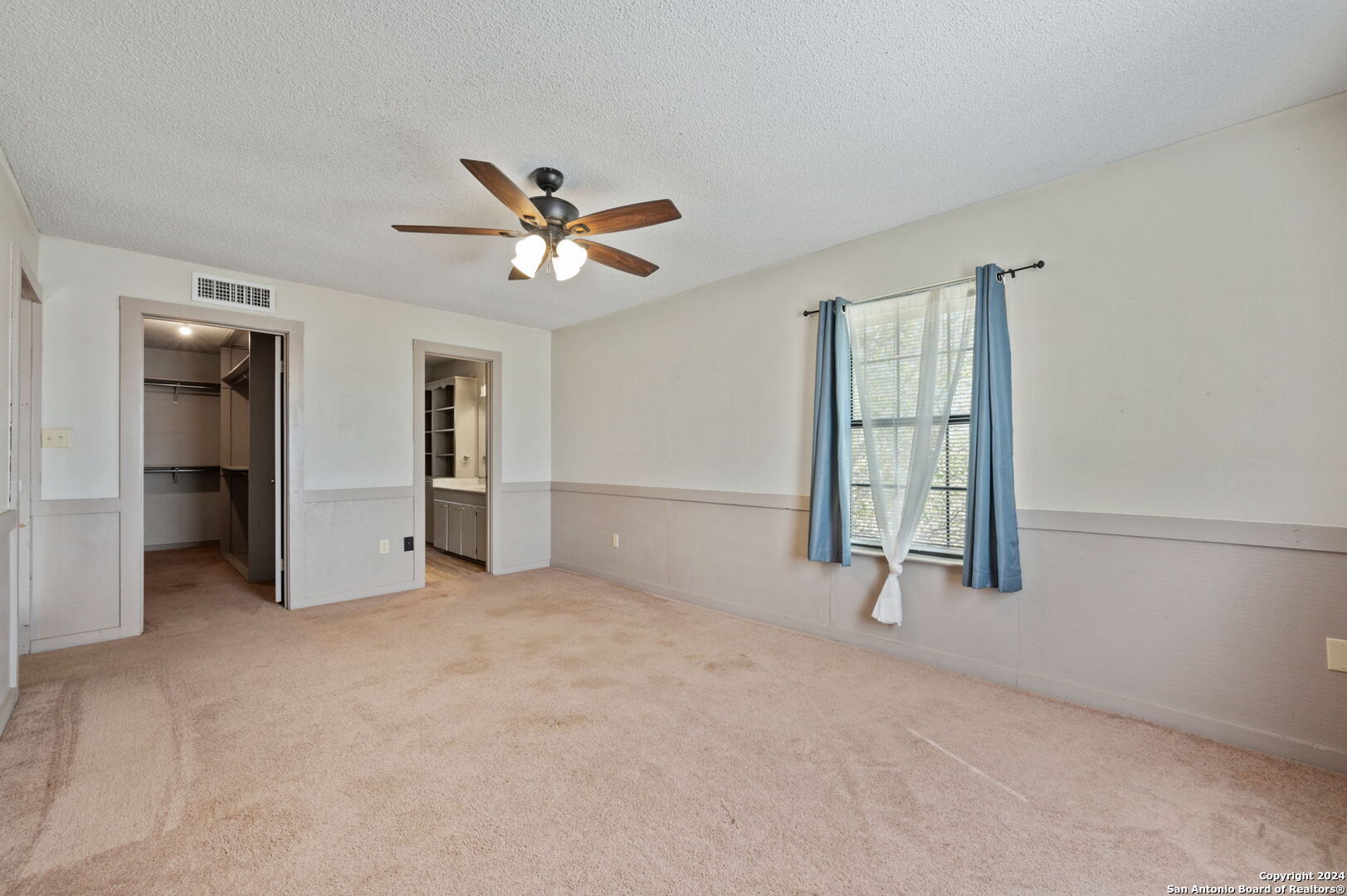 795 Highway 16 Jourdanton, TX 78026 - Photo 11 of 25 an empty room with chandelier fan and windows