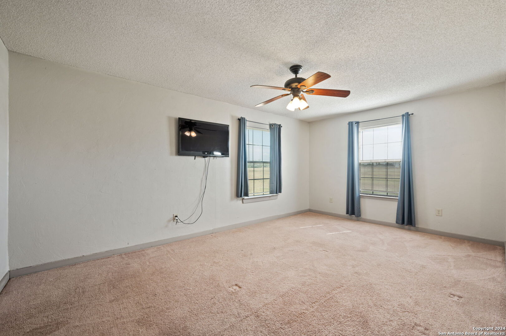 795 Highway 16 Jourdanton, TX 78026 - Photo 16 of 25 a view of a room with a ceiling fan and a window