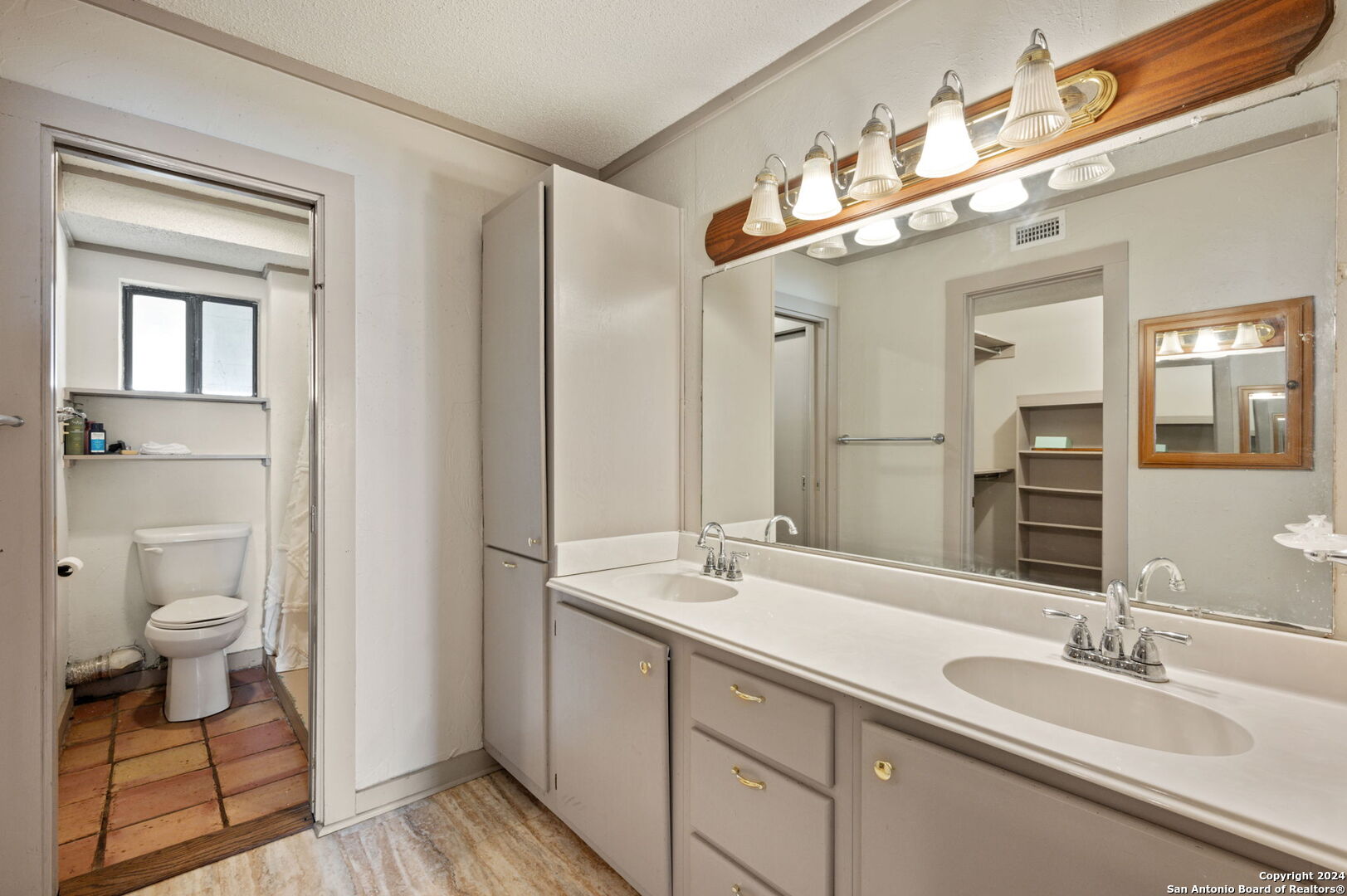 795 Highway 16 Jourdanton, TX 78026 - Photo 18 of 25 a bathroom with a double vanity sink and a mirror