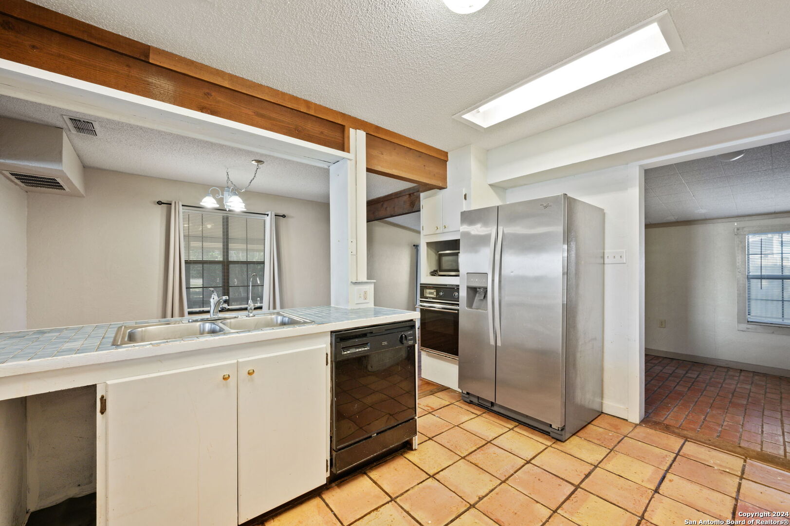 795 Highway 16 Jourdanton, TX 78026 - Photo 5 of 25 a kitchen with stainless steel appliances a sink and a refrigerator