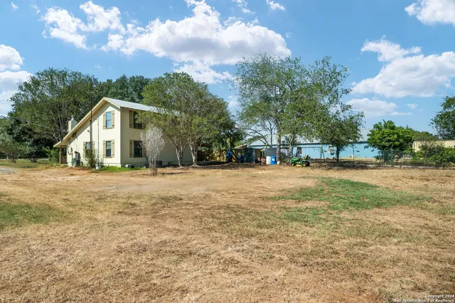 a view of a house with backyard and a tree