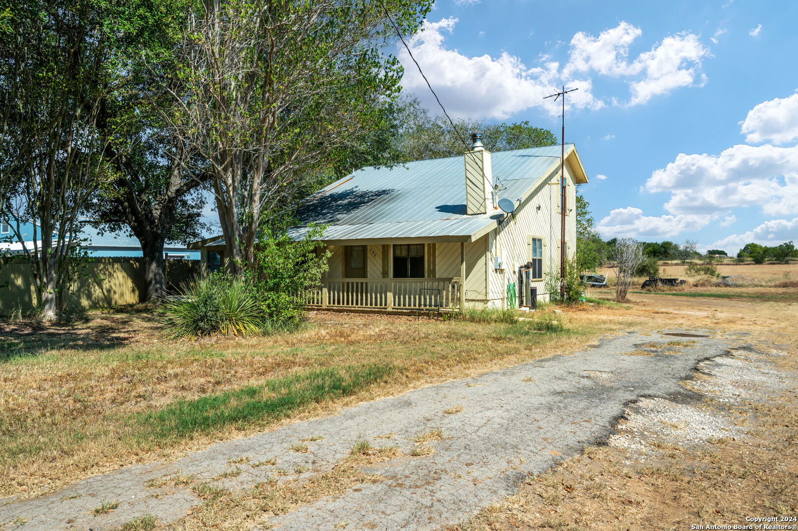795 Highway 16 Jourdanton, TX 78026 - Photo 9 of 25 a view of a house with backyard and a tree