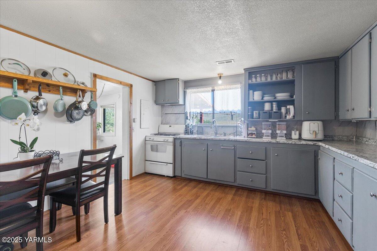 101 West Slavin Road Yakima, WA 98903 - Photo 13 of 37 a kitchen with a wooden floor and white appliances