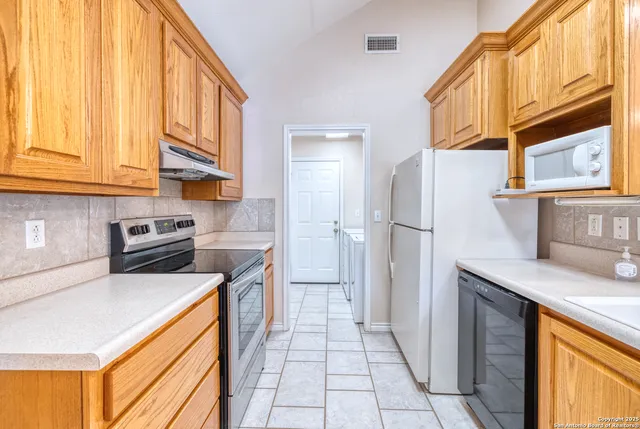 a kitchen with stainless steel appliances granite countertop a refrigerator and a stove