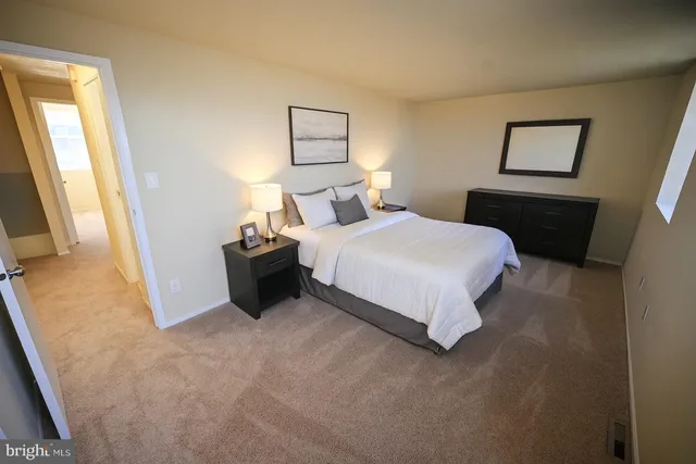 a bedroom with a bed and a flat tv screen on dresser