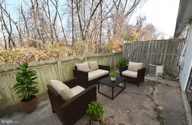 a view of a patio with couches and a table and chairs with wooden fence