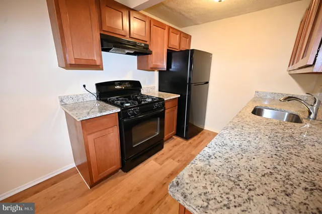 a kitchen with stainless steel appliances granite countertop a refrigerator stove and sink