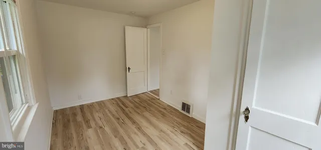 a view of a room with wooden floor and a window