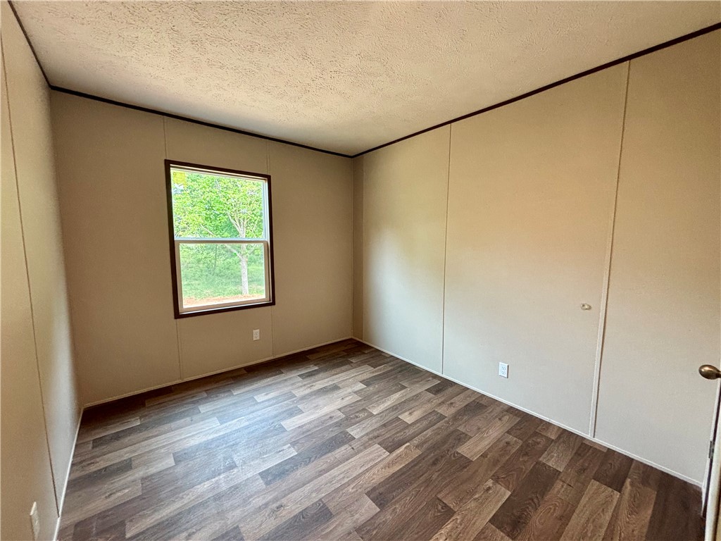 703 Double Springs Road Townville, SC 29689 - Photo 13 of 22 This inviting bedroom features rich wood flooring, offering a comfortable and serene retreat.