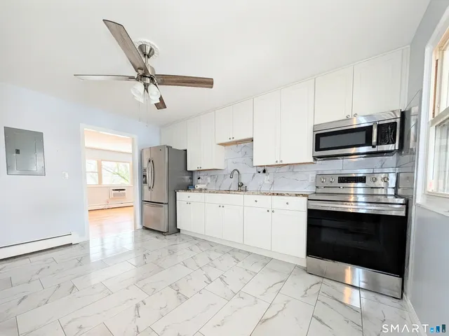 a kitchen with stainless steel appliances granite countertop a stove microwave and a refrigerator