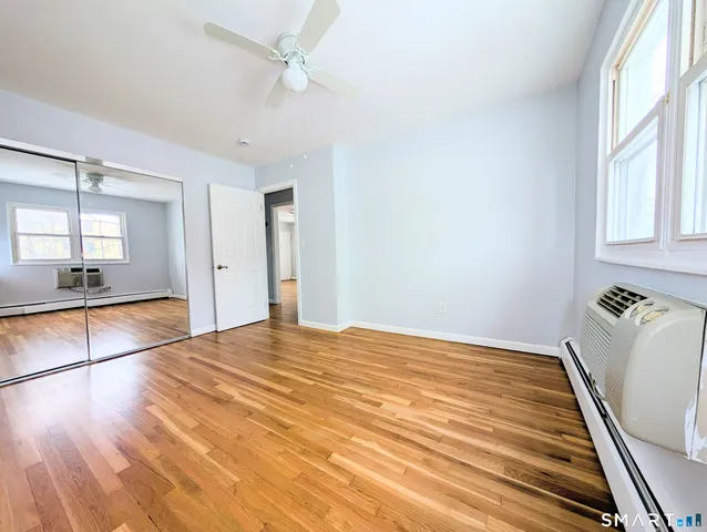 a view of a room with wooden floor and ceiling fan