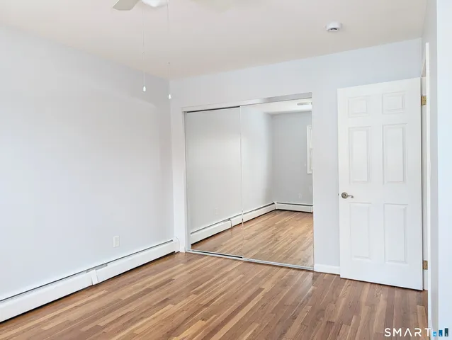 a view of an empty room with wooden floor