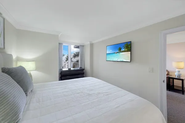 a bedroom with a large bed and a chandelier