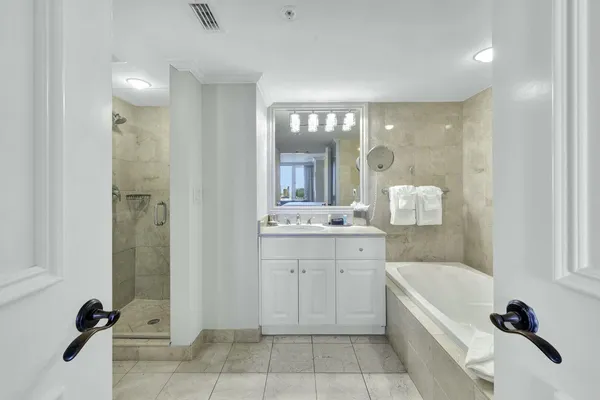 a bathroom with a bathtub shower sink and mirror