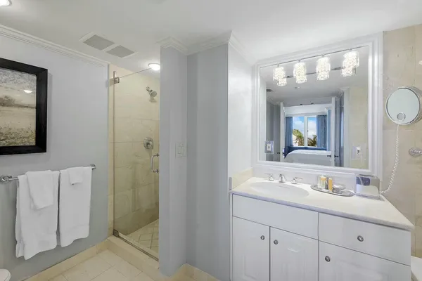 a bathroom with a double vanity sink mirror and shower