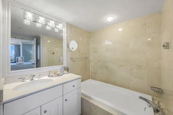 a bathroom with a sink a large mirror and a bathtub