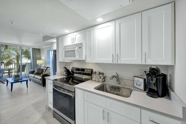a kitchen with cabinets appliances a sink and a counter top space