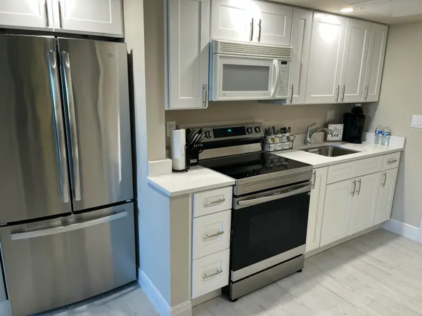 a kitchen with white cabinets and stainless steel appliances