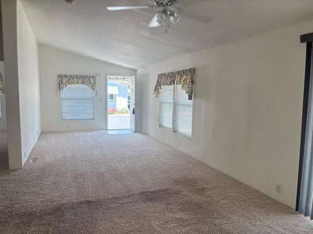 a view of a big room with windows and chandelier fan