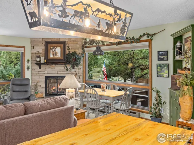 a living room with furniture a fireplace and a floor to ceiling window