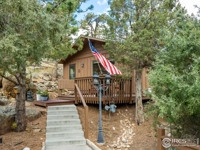 a view of wooden house with a small yard