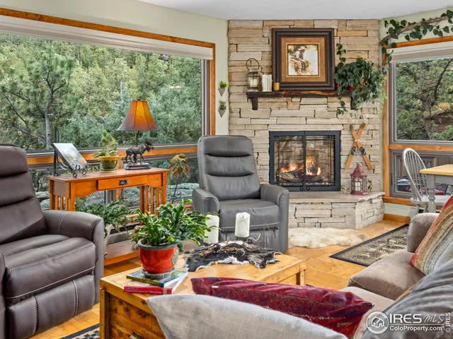 a living room with furniture a fireplace and a floor to ceiling window