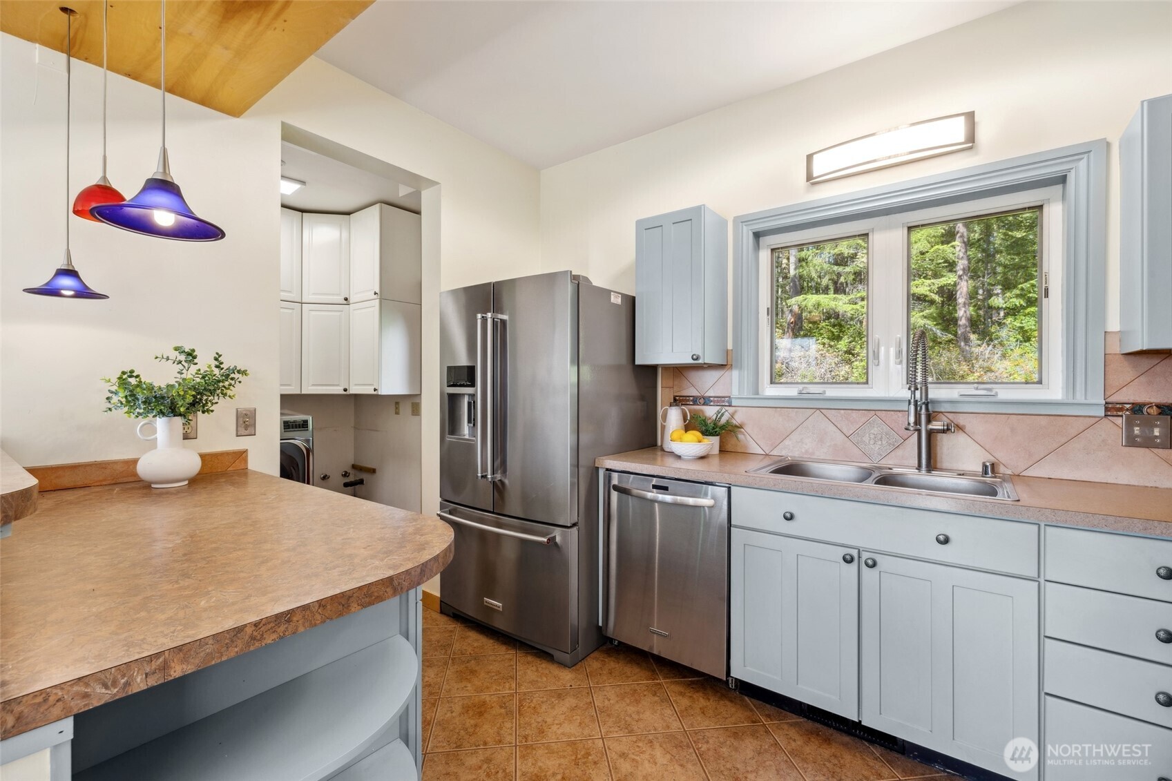 4987 Mutiny Bay Road Freeland, WA 98249 - Photo 11 of 40 a kitchen with stainless steel appliances granite countertop a sink a refrigerator and a window