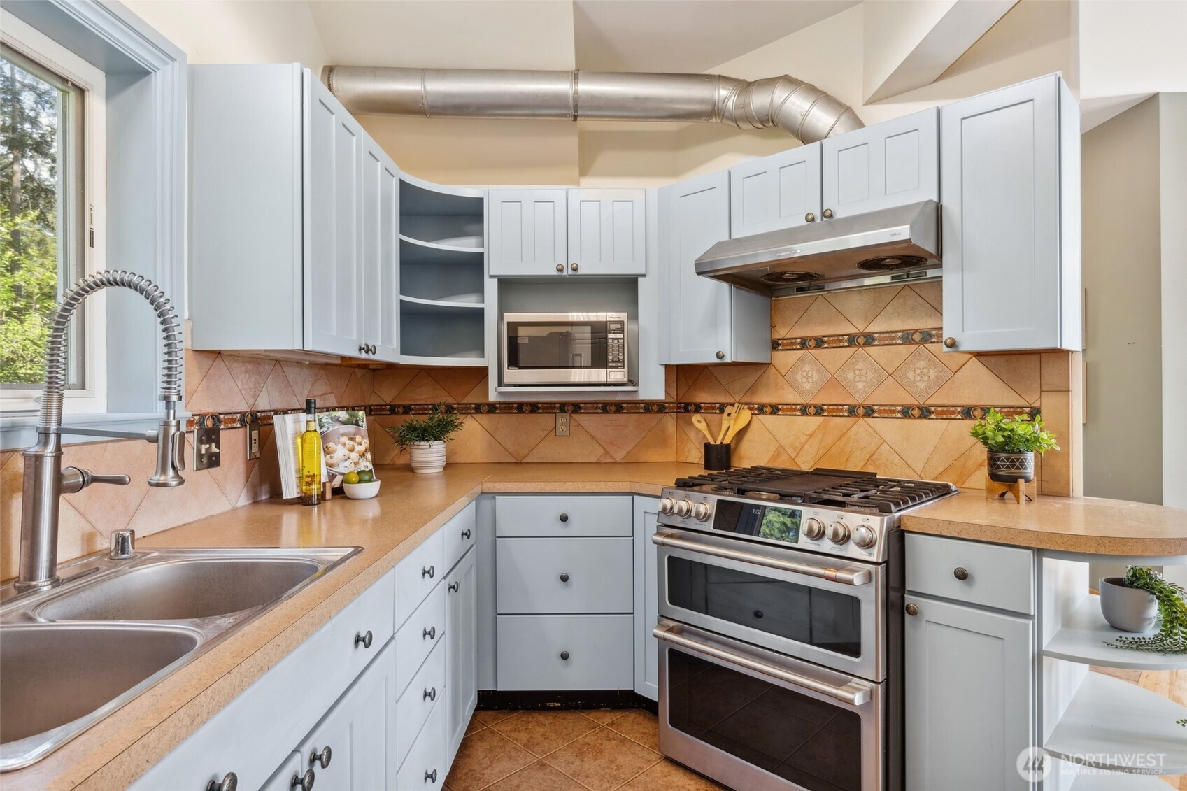 4987 Mutiny Bay Road Freeland, WA 98249 - Photo 12 of 40 a kitchen with stainless steel appliances granite countertop a stove and a sink