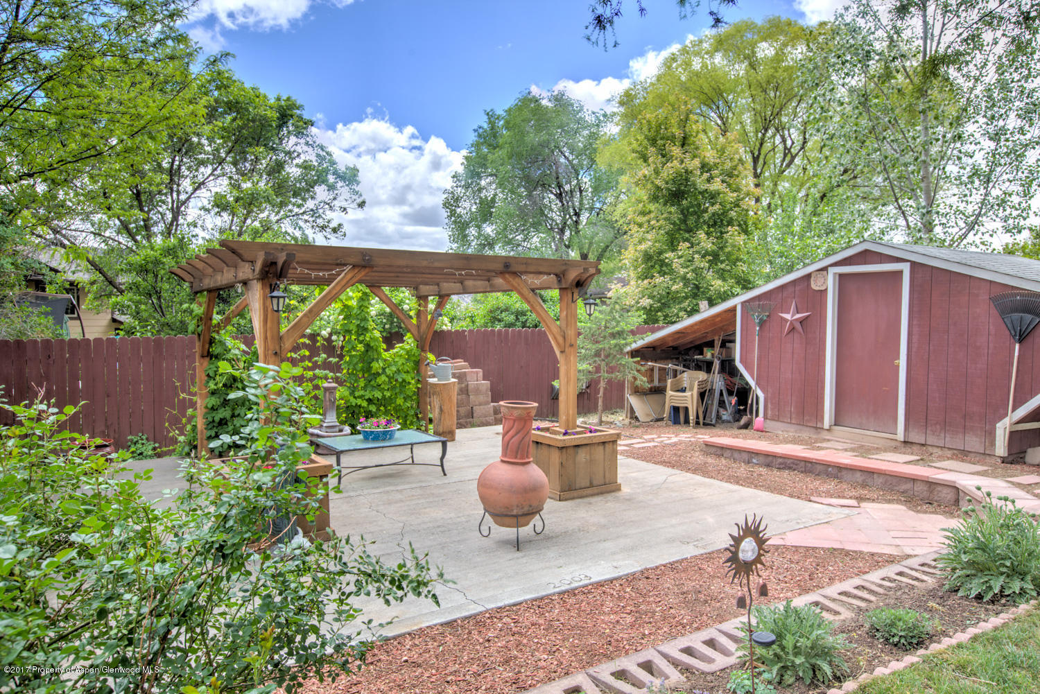875 East 7th Street Rifle, CO 81650 - Photo 24 of 27 a backyard of a house with table and chairs potted plants and large tree
