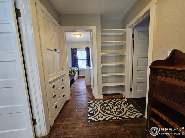 a room with walk in closet and wooden floor