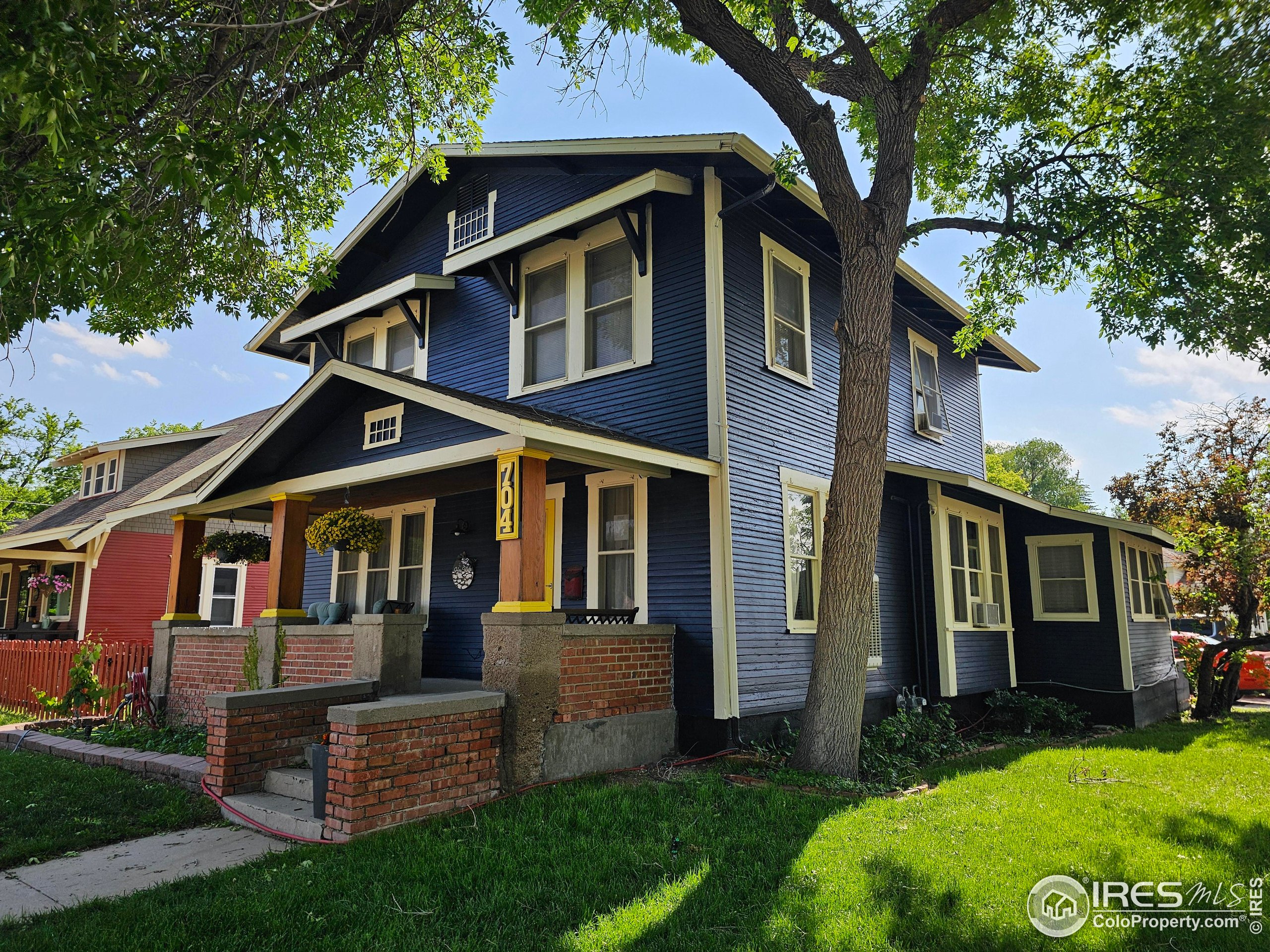 704 South 3rd Avenue Sterling, CO 80751 - Photo 34 of 35 a front view of a house with a yard and trees