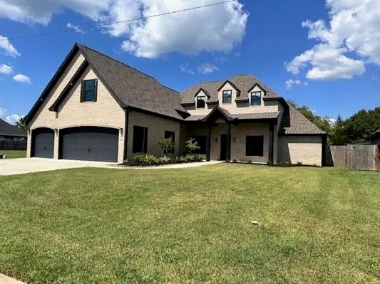 a front view of a house with a garden and yard