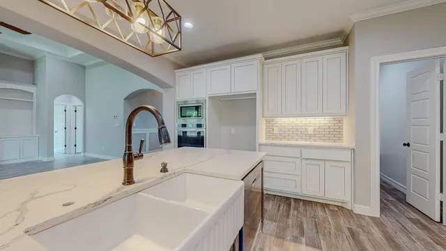 a kitchen with stainless steel appliances granite countertop a stove a sink a refrigerator and cabinets