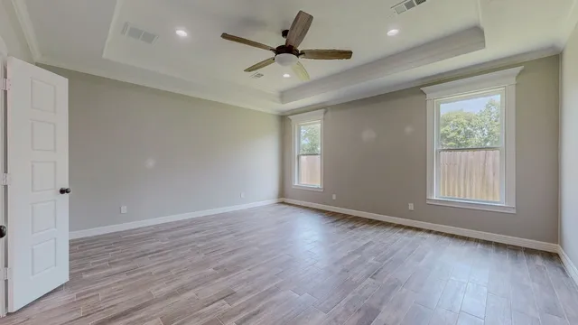 wooden floor in an empty room with a fan