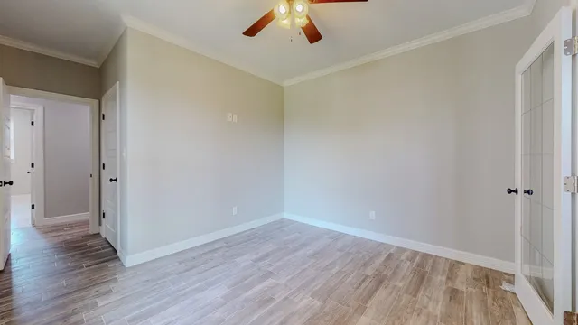 a view of an empty room with wooden floor