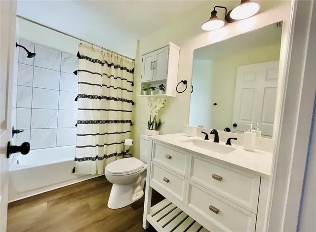 a bathroom with a sink toilet mirror and shower