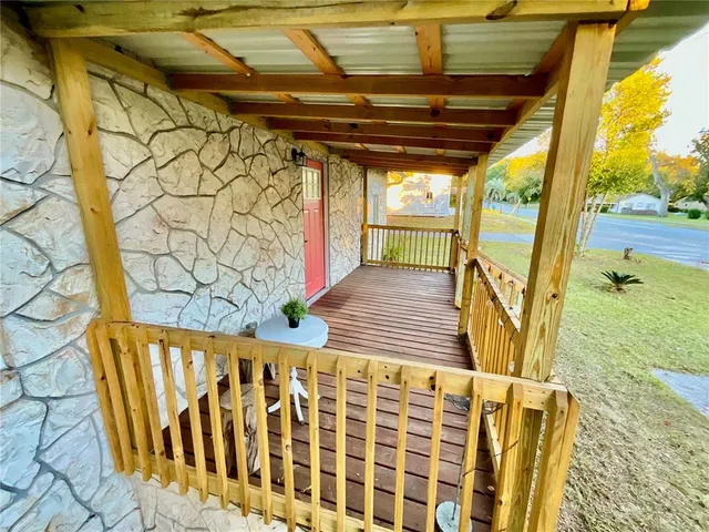 a view of a porch with wooden floor and fence