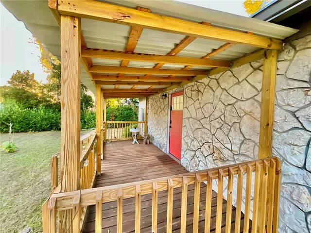 a backyard of a house with plants and large tree