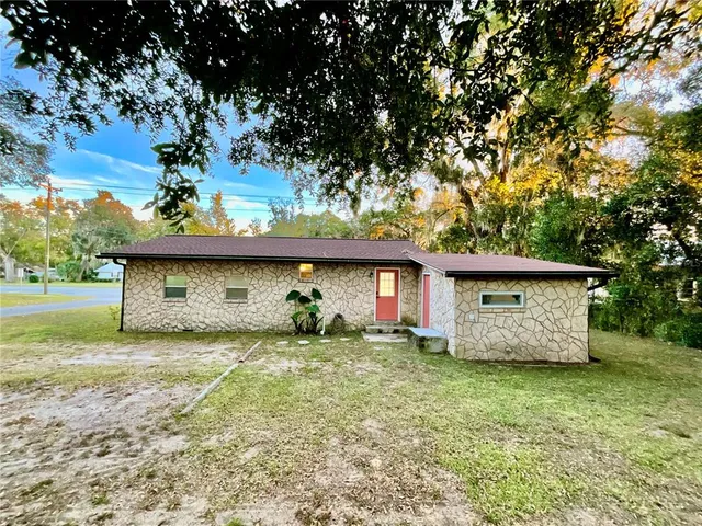 a front view of a house with a garden and yard
