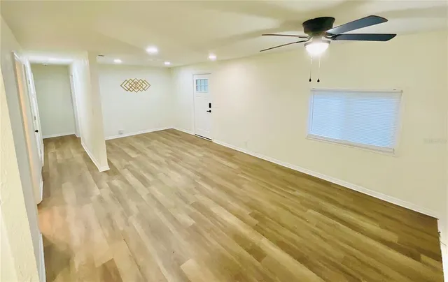 a view of empty room with wooden floor