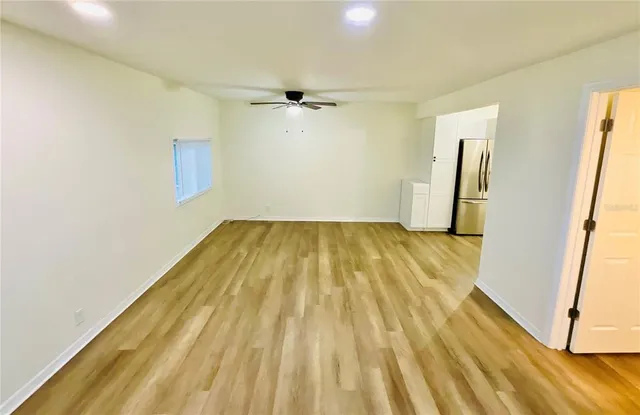 a view of a room with wooden floor and a ceiling fan