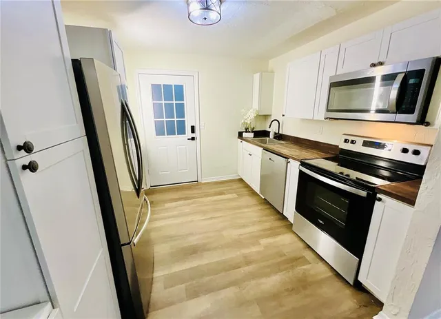 a kitchen with stainless steel appliances a stove microwave and sink