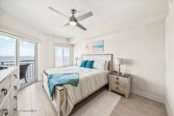 a bedroom with a bed and large windows