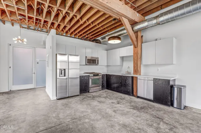 a kitchen with stainless steel appliances granite countertop a refrigerator and a sink