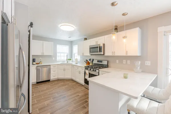 a kitchen with a sink a counter top space stainless steel appliances and cabinets