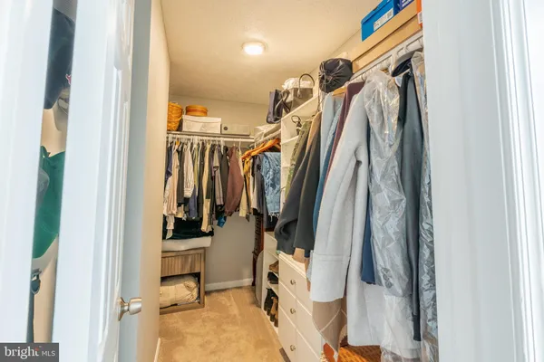 a view of walk in closet with clothes and shoes